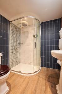a bathroom with a shower and a toilet and a sink at Harbour Inn in Porthleven