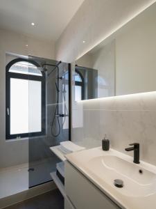 a white bathroom with a sink and a shower at Julie's Boutique Guesthouse Ghent in Ghent