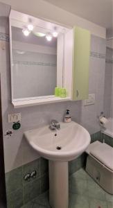 ein Badezimmer mit einem Waschbecken, einem Spiegel und einem WC in der Unterkunft Bicycle road in Imperia