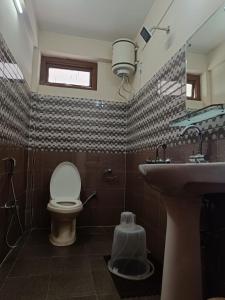 een badkamer met een toilet en een wastafel bij Vamoose Mountain Mist in Tawang