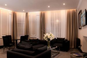 uma sala de estar com sofás e um vaso de flores em County Hotel & County Aparthotel Newcastle em Newcastle upon Tyne