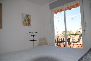 a bedroom with a bed and a balcony with a table at Vera Playa Naturista, Mar y Sol in Vera +42 photos