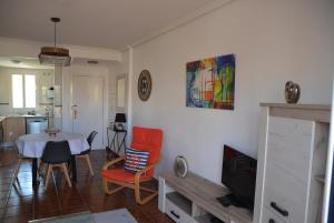 a kitchen and living room with a table and chairs at Vera Playa Naturista, Mar y Sol in Vera