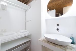La salle de bains blanche est pourvue d'un lavabo et d'un miroir. dans l'établissement BERGAMO art - PORTA AGOSTINO, à Bergame