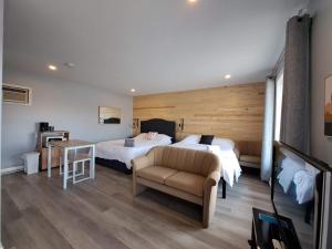 1 dormitorio con cama, sofá y mesa en Habitations Zenith, en Sainte-Anne-de-Beaupré