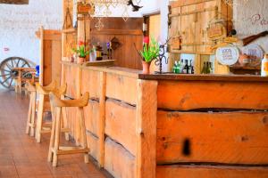 a wooden bar in a restaurant with a counter and chairs at Palmse Distillery Guesthouse - Self Check-in in Palmse +16 photos