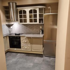 een keuken met witte kasten en een roestvrijstalen koelkast bij Laksevåg Apartment in Bergen
