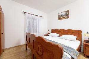 Dobrinj的住宿－Lorenzo in Klanice (Haus 2 für 6 Personen)，一间卧室设有一张木床和一个窗户。