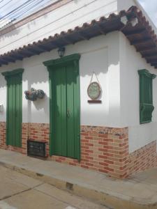 un edificio con puertas verdes a un lado en Apartahotel El Mirador, en Zapatoca