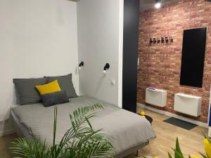 a bedroom with a bed and a brick wall at Apartamenty Silver Place in Szczecin