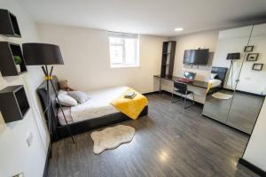 a bedroom with a bed and a desk with a computer at Modern Studio next to University of Birmingham in Birmingham