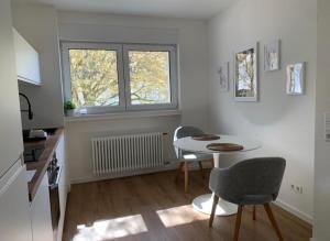 巴登－巴登的住宿－Eckberg Apartment near City Centre & Nature，厨房配有桌子和两把椅子,设有窗户。