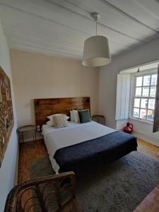 Historic Torres Vedras في توريس فيدراس: غرفة نوم بسرير ابيض كبير ونافذة