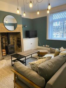 uma sala de estar com um sofá e uma mesa em Cobble Cottage em Lindley