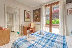 a bedroom with a bed and a desk and a window at B&B San Rocco in Capo di Ponte
