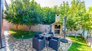 um pátio com uma mesa, cadeiras e árvores em Villa Dalia em Mostar