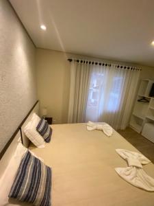 1 dormitorio con 1 cama con 2 toallas en Ipê Amarelo Cama e Café en Gramado