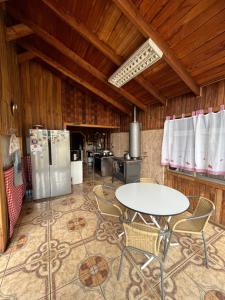 a kitchen with a table and chairs in a room at Hostel del Valle in Recinto