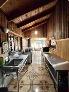 uma cozinha com lavatórios de aço inoxidável e paredes de madeira em Hostel del Valle em Recinto