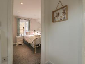1 dormitorio con 1 cama y una foto en la pared en Rose Cottage, en Whitby