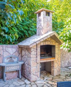 a stone pizza oven with a sink in a yard at Villa Dalia in Mostar