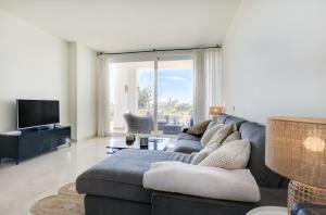 sala de estar con sofá y TV en Lagoon suites en Casares