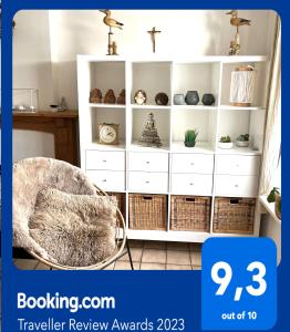 een witte boekenplank met een stoel in een kamer bij Chez’ Elle in Blankenberge