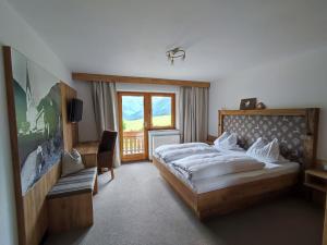 a bedroom with a large bed and a window at Haus Alpina in Berwang