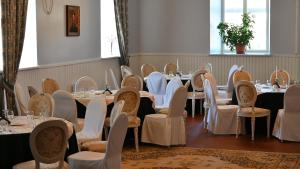 una fila de mesas y sillas en una habitación en Palmse Distillery Guesthouse en Palmse