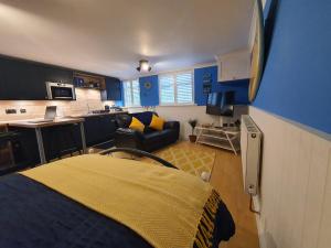 a bedroom with a bed and a living room at Hayling Hideaway, private cosy annex near to beach in South Hayling