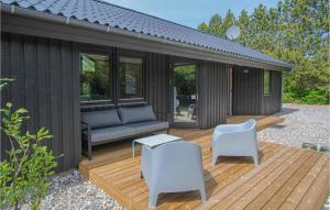 een houten terras met een bank en stoelen erop bij Stunning Home In Sams With House Sea View in Kolby Kås