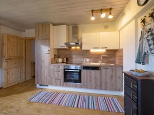 a kitchen with wooden cabinets and a stainless steel refrigerator at Im Riederhof in Going am Wilden Kaiser