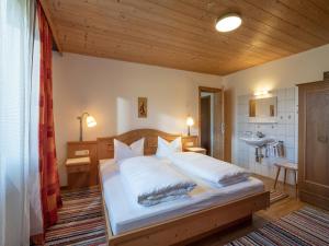 a bedroom with a large bed with a wooden ceiling at Im Riederhof in Going am Wilden Kaiser