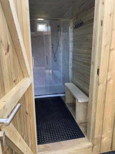 a wooden bathroom with a shower with a glass door at Rivers View Holidays in Westbury on Severn