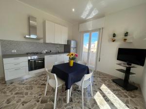 una cocina con una mesa con un jarrón de flores. en Angolo del Mare - Case Libeccio e Blu Marino en Favignana