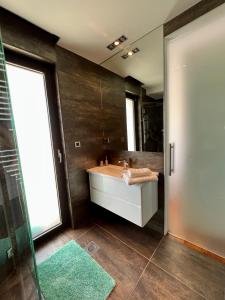 a bathroom with a sink and a shower and a mirror at Luxury Laurus Penthouse with awesome sea view in Primošten