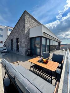 a patio with a wooden table and chairs on a building at Luxury Laurus Penthouse with awesome sea view in Primošten