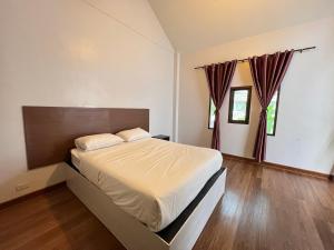 een slaapkamer met een groot bed en houten vloeren bij The Green Season Resort in Ban Mae Kham Lang Wat