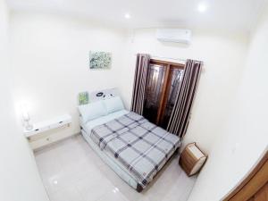 a small bedroom with a bed and a tub at Rumah Bungur, Purwomartani in Kalasan