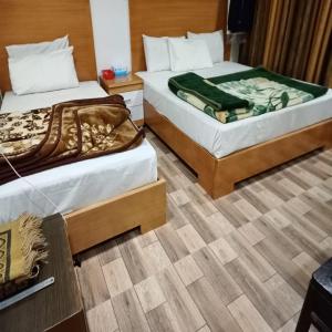 2 letti posti uno accanto all'altro in una stanza di Hotel New Star View a Bahawalpur