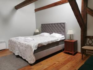 ein Schlafzimmer mit einem Bett und einem Tisch mit einer Lampe in der Unterkunft Palmse Manor Guesthouse in Palmse