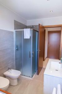 een badkamer met een douche, een toilet en een wastafel bij Rossellini Home a Gabicce Mare by Yohome in Gabicce Mare