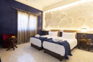 - 2 lits dans une chambre aux murs bleus dans l'établissement Albakech Boutique Hôtel & Spa, à Marrakech