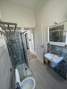 La salle de bains est pourvue d'une douche et d'un lavabo. dans l'établissement Angolo del Mare - Case Libeccio e Blu Marino, à Favignana