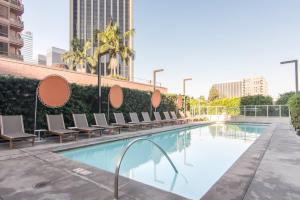 una piscina con tumbonas junto a un edificio en Downtown Studio w Gym Pool nr Metro Center LAX-279, en Los Ángeles