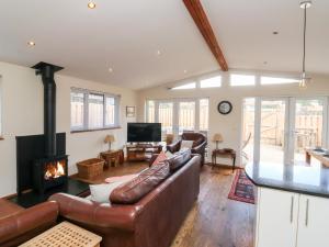 a living room with a leather couch and a fireplace at Gloccamaura in Newton Abbot