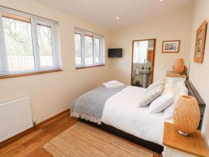 a bedroom with a bed and two windows at Gloccamaura in Newton Abbot