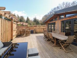 a patio with a wooden table and chairs at Gloccamaura in Newton Abbot