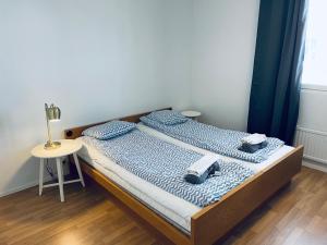 a bedroom with a bed and a table with a lamp at Kalastajankuja Apartment in Espoo