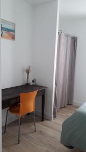 sypialnia z biurkiem z krzesłem i łóżkiem w obiekcie LOCABEACH w mieście Longeville-sur-Mer